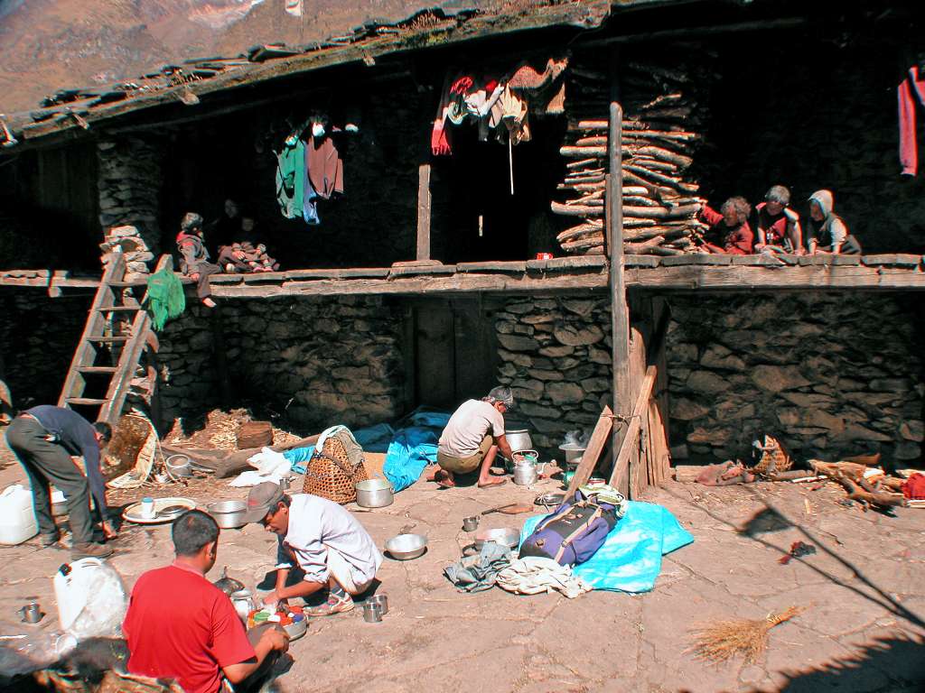 Manaslu 06 02 Lihi Lunch In Local House Yard We stopped for lunch in the back of a local house, with wood stacked high, clothes drying, barley let out to dry, and children looking on.